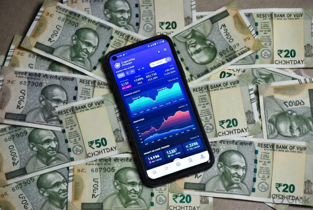 How to Convert Cryptocurrency to Cash: A Practical Guide 5 Indian rupee notes beside a phone showing a crypto to cash conversion app