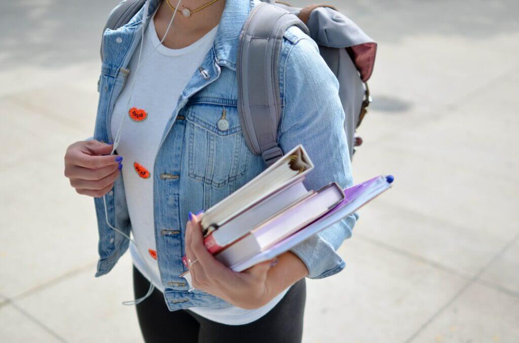 A college student holding books in hand
